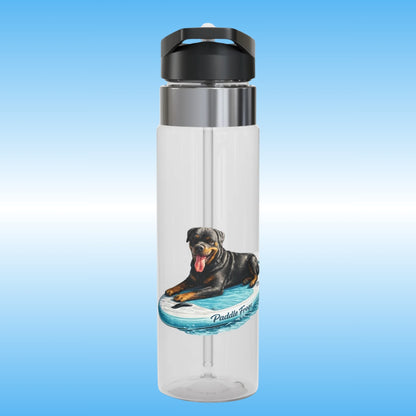 A clear plastic water bottle with a black flip-top lid and a stainless steel collar, featuring a printed graphic of a Rottweiler dog paddleboarding on a blue board. The bottle is centered against a light blue gradient background.