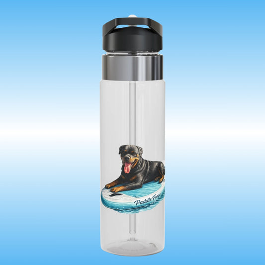A clear plastic water bottle with a black flip-top lid and a stainless steel collar, featuring a printed graphic of a Rottweiler dog paddleboarding on a blue board. The bottle is centered against a light blue gradient background.