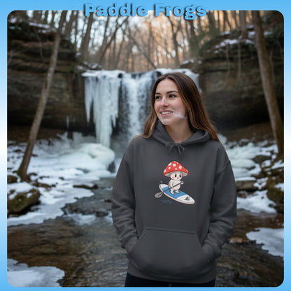 Shiro rides the Divine Escape Paddle Frogs™ Hoodie – Charcoal Gray Woman wearing a hoodie with a cartoon design in front of a snowy waterfall.