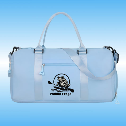 A light blue waterproof duffel bag with shiny blue handles and a black 'Paddle Frogs' frog logo printed on the front, set against a blue gradient background.