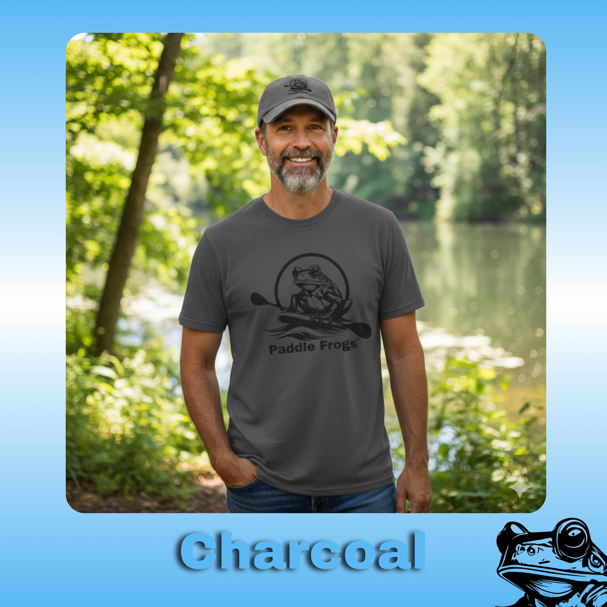 The original paddle boarding Tee in Charcoal Gray | Man wearing a gray t-shirt with a logo and text, standing outdoors by a lake.