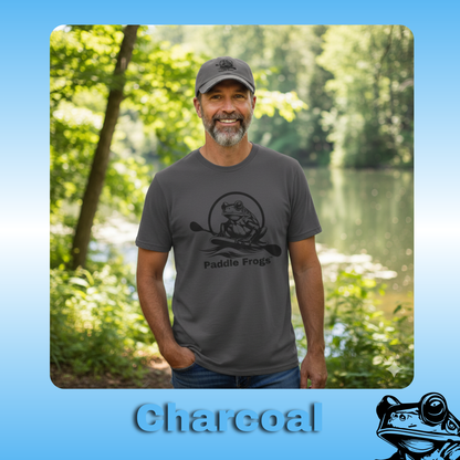 The original paddle boarding Tee in Charcoal Gray | Man wearing a gray t-shirt with a logo and text, standing outdoors by a lake.