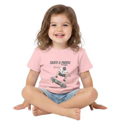 Toddler Skateboard Tee Germ "Skate & Paddle Frogs™ Pink sitting crisscross applesauce on a transparent background