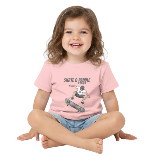 Toddler Skateboard Tee Germ "Skate & Paddle Frogs™ Pink sitting crisscross applesauce on a transparent background