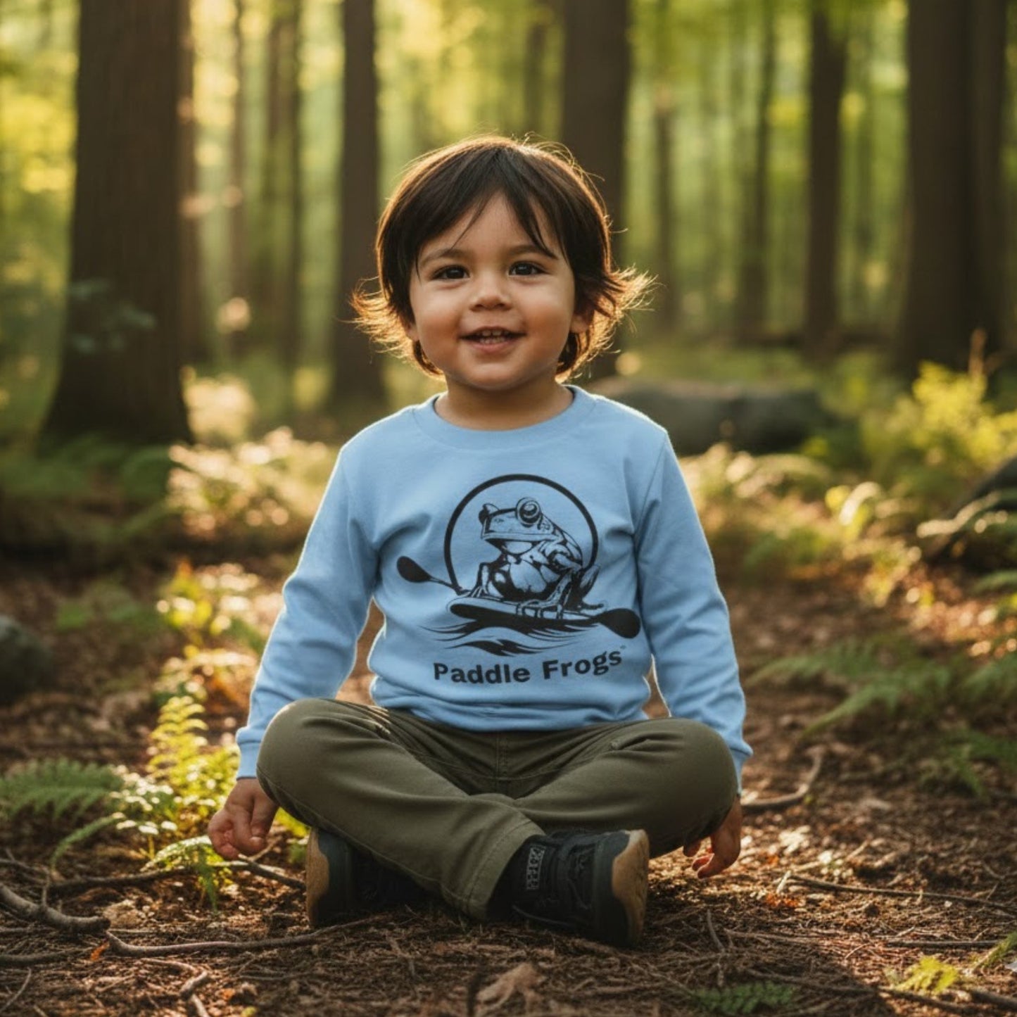 Toddler's in Balance | Long Sleeve Tee | Paddle Frogs™ sitting crisscross applesauce wearing light blue 3 year old Native American boy in the TN forest