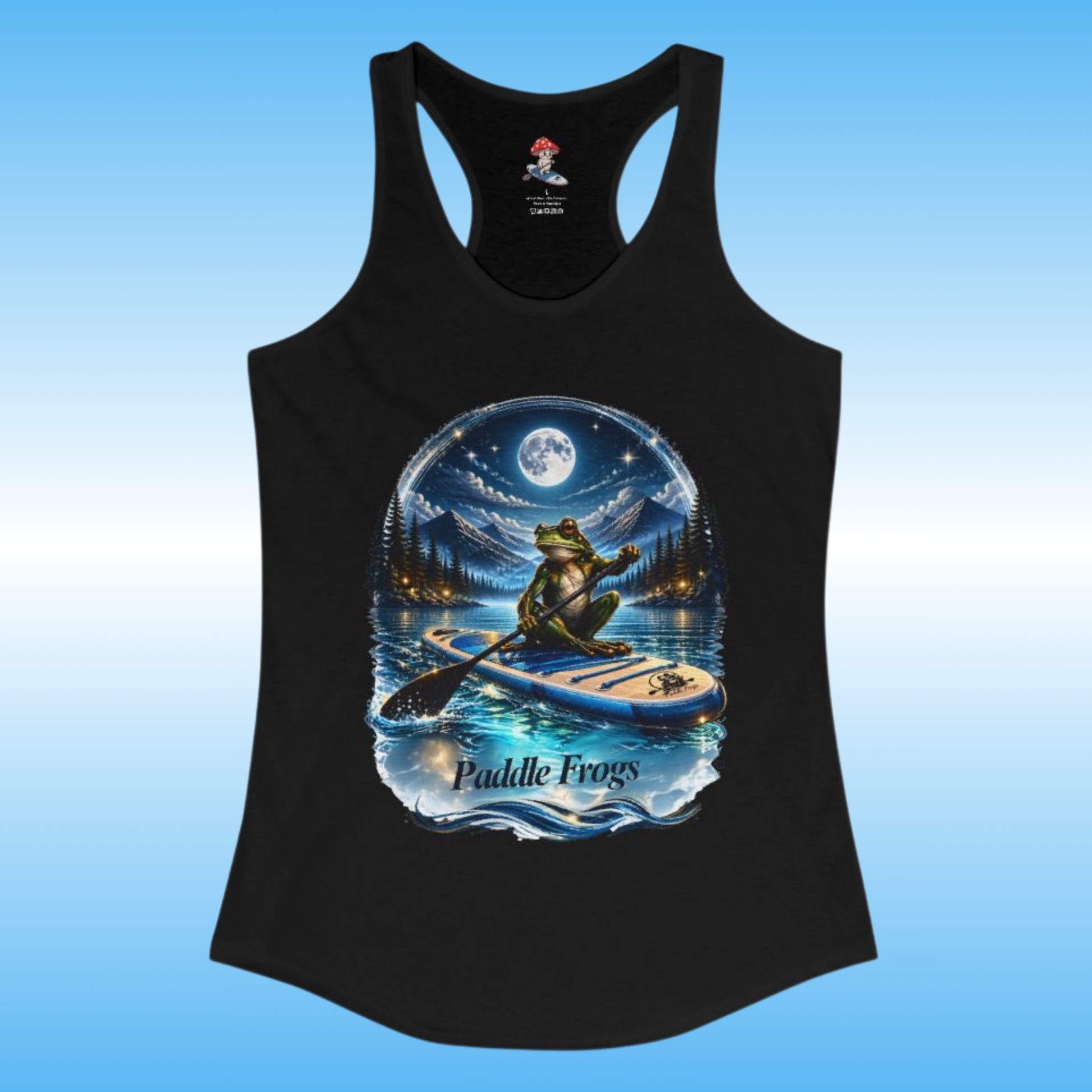 A black racerback tank top featuring a large circular graphic of a frog paddleboarding on water under a full moon, with the text 'Paddle Frogs' printed below the design. The tank top is displayed against a light blue gradient background.