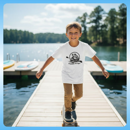 Child walking on a dock by a lake wearing a white t-shirt with a logo. White action shot - Kids Tee (Big Fit) 7 Colors | Paddle Frogs Kids