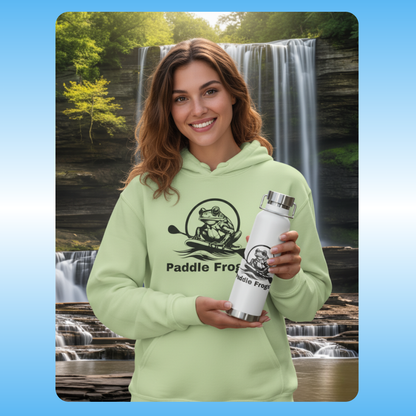 Woman wearing a green hoodie with Paddle Frog logo holding a white tumbler in front of a waterfall. White copper-insulated vacuum sealed bottle