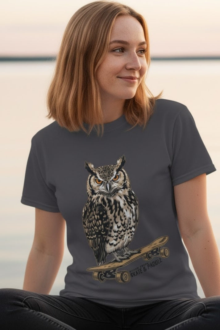 Wise Owl's Skate & Paddle Tee being modeled by a young lady sitting crisscross applesauce by the sea.