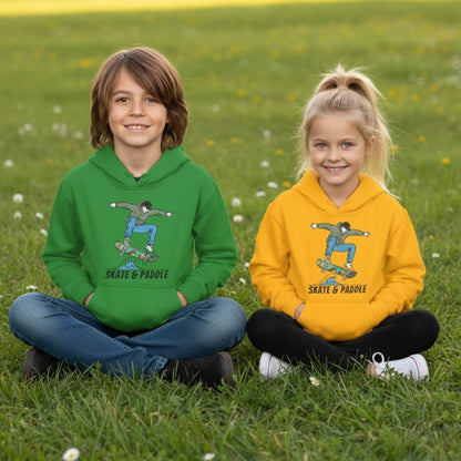 a boy and a girl sitting crisscross applesauce in the grass wearing green and a yellow "Skate & Paddle" Chlorophyll Cruiser Youth Hoodie Paddle Frogs™ 
