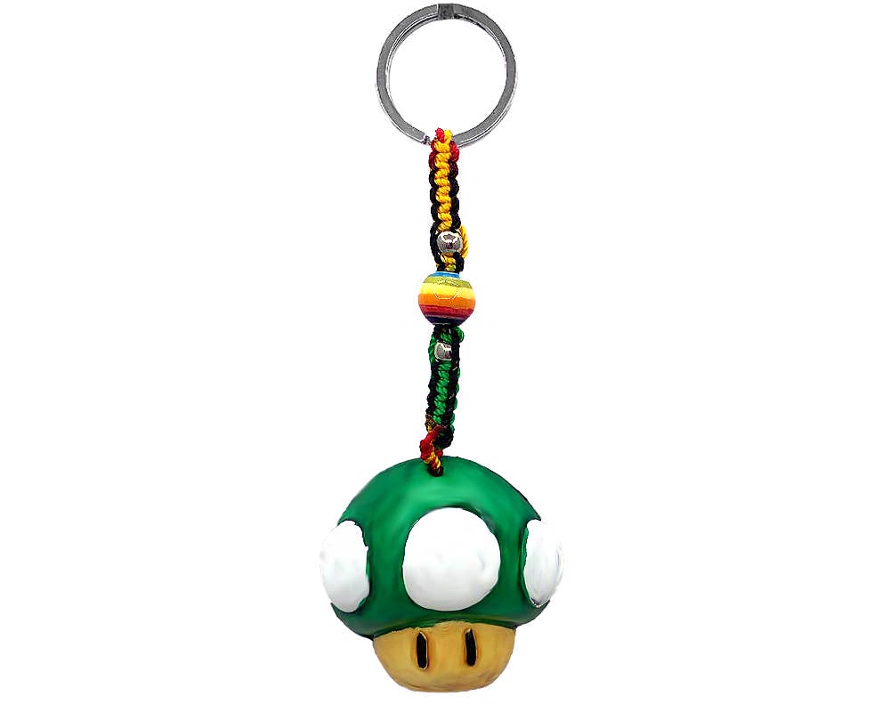 A Super Mushroom keychain featuring a 3D green and white mushroom charm with a gold mouth, attached to a braided cord with colorful beads and a silver metal key ring, shown against a plain white background.