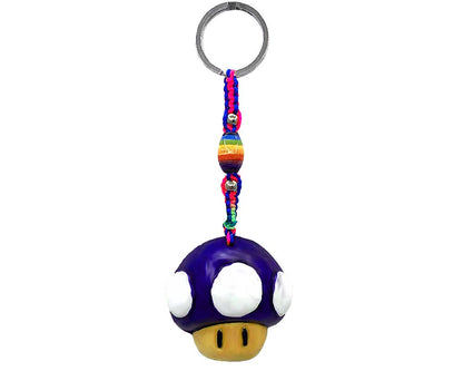 A Super Mushroom keychain featuring a purple and white mushroom charm with a yellow face, attached to a colorful braided cord with rainbow beads and a silver metal key ring, shown on a plain white background.