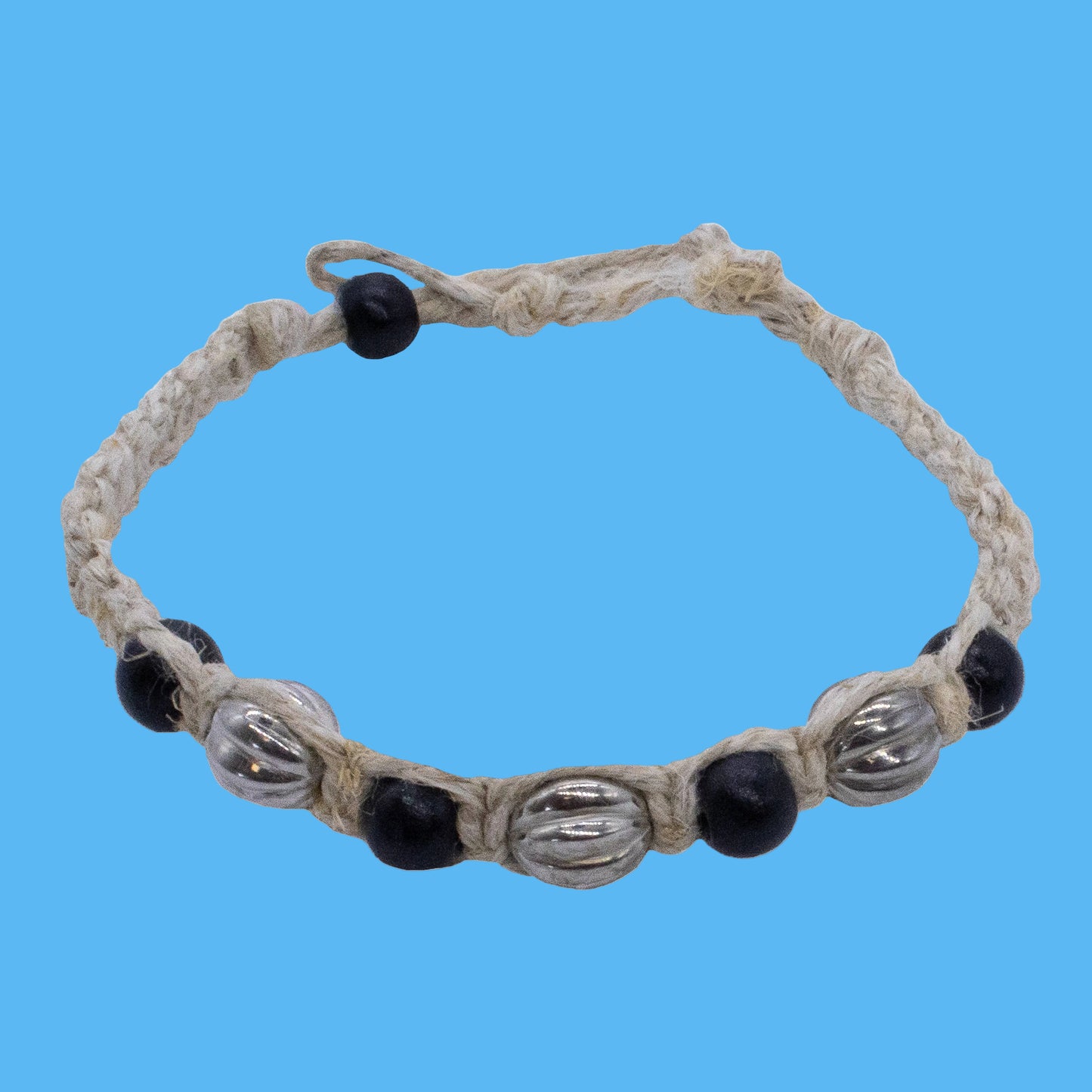 A braided rope bracelet with alternating black beads and polished silver metallic beads, shown on a plain white background.
