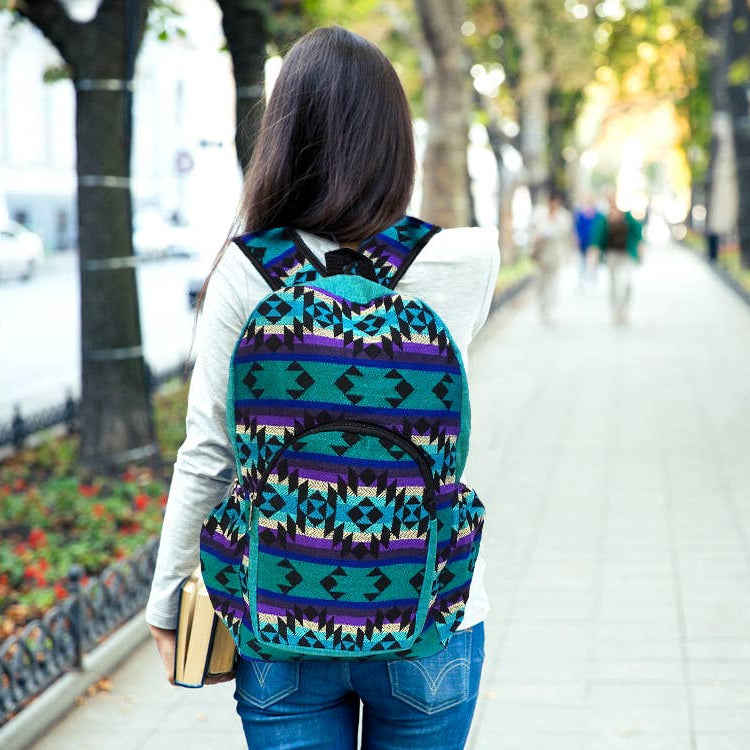Person walking on a sidewalk with a colorful patterned backpack
