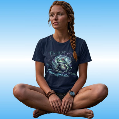 A woman with a braid sits cross-legged against a blue gradient background, wearing a navy blue t-shirt with a 'Paddle Frog' graphic print of a paddle board on the front.
