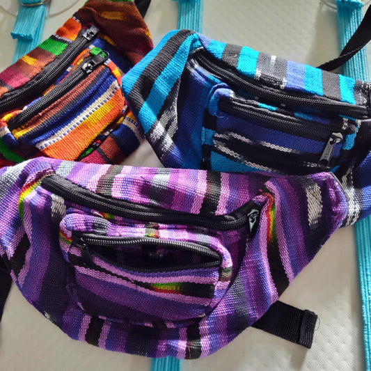 Colorful striped fanny packs on a light background