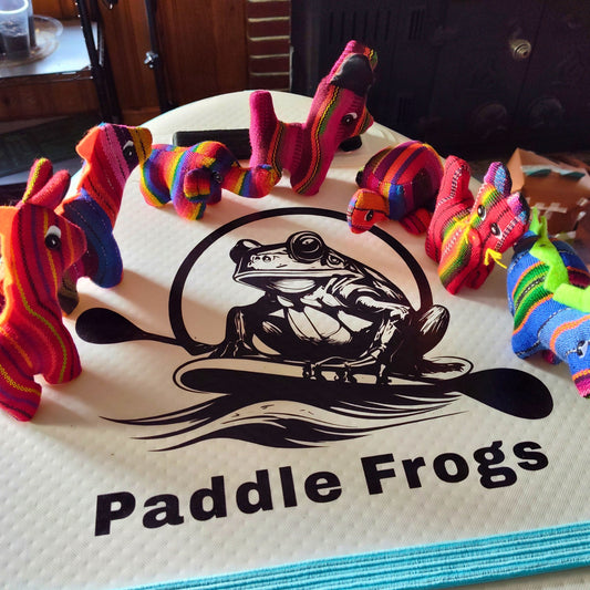 Colorful stuffed animals toys on a paddleboard with 'Paddle Frogs' branding.
