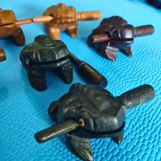 Wooden frogs percussion instrument on a blue textured surface
