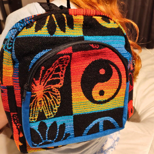 Colorful bag with butterfly and yin-yang design held by a person.