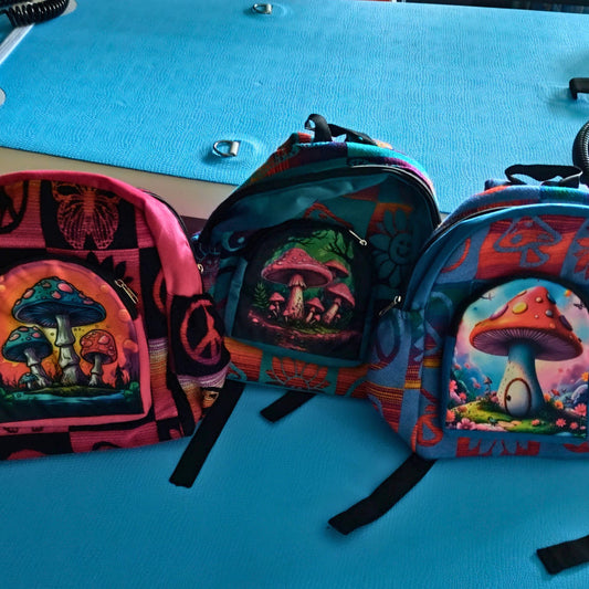 Three colorful backpacks with mushroom designs on a blue surface