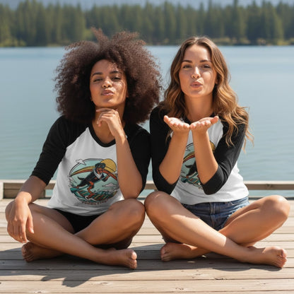 Two women sitting crisscross applesauce on a dock by a lake, wearing matching baseball jerseys.