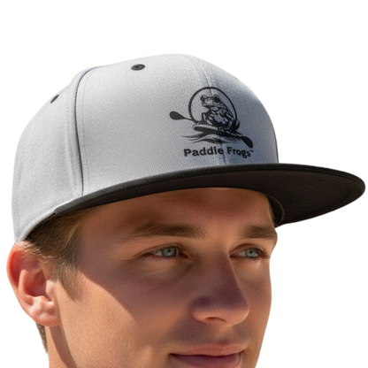 Gray cap with black brim and Paddle Frogs logo worn by a person on a transparent background