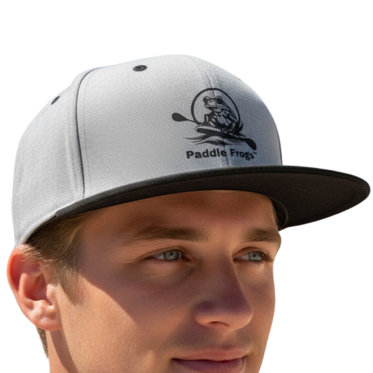 Gray cap with black brim and Paddle Frogs logo worn by a person on a transparent background